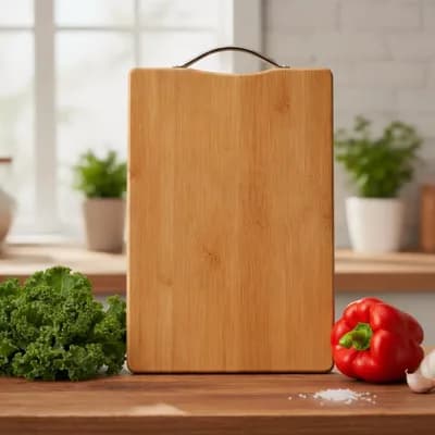 A plain bamboo board with a steel handle, standing among tomatoes and broccoli