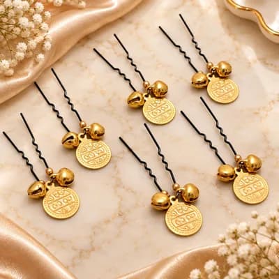 A close view of the coin and bell charms on black pins