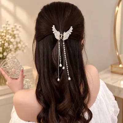 The clip holding a half-up style in long dark hair, its pearl strands falling down the back