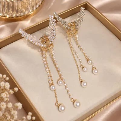 Two pearl wing clips in a gold tray