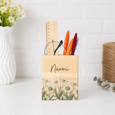 A pen holder printed with daisies and the name Naomi