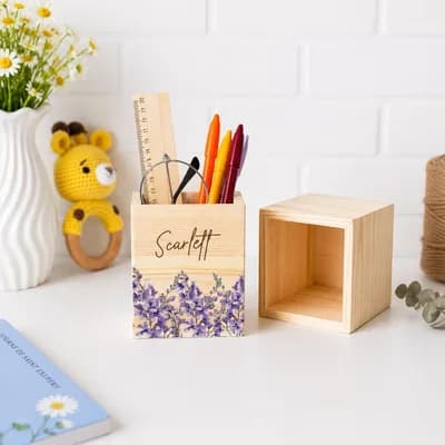 A pen holder printed with purple flowers and the name Scarlett, beside an empty one