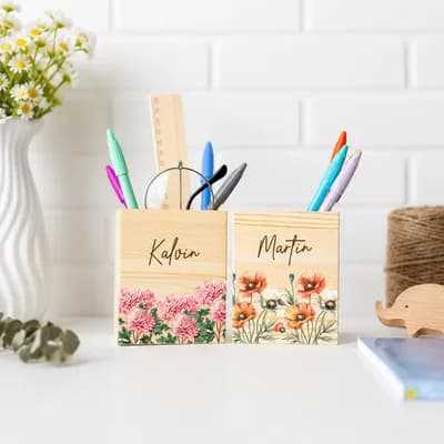 Two pen holders printed with pink and orange flowers and the names Kalvin and Martin