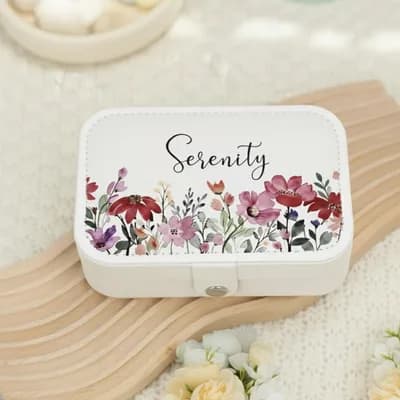A white jewelry box printed with “Serenity” in script above red and purple wildflowers