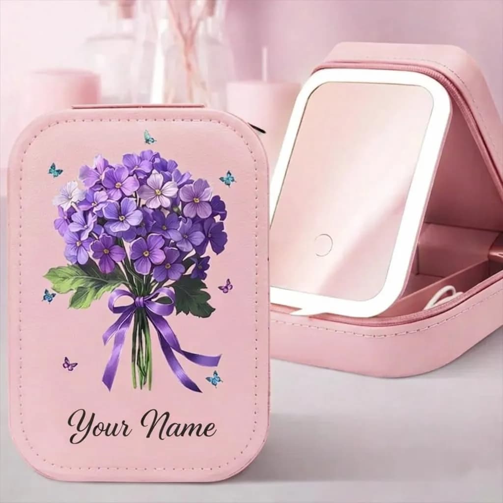 A pink makeup case printed with a bouquet of purple flowers tied with a ribbon, with “Your Name” below, beside the open case