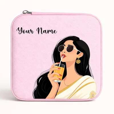 A pink mini jewelry box printed with a woman in sunglasses and a cream saree sipping juice through a straw, with “Your Name” above her