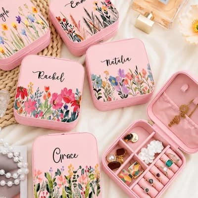 Pink mini jewelry boxes printed with flowers and the names Angela, Emma, Rachel, Natalia and Grace, beside an open box