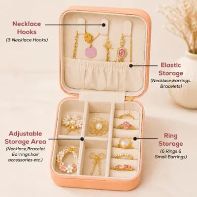 The open peach box, labeled: three necklace hooks and an elastic pocket in the lid, an adjustable compartment area and a ring roll for six rings in the base