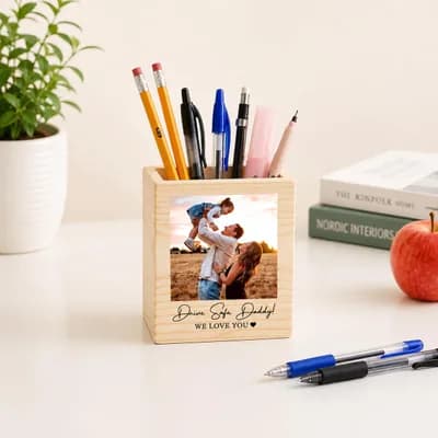 The same pen holder on a desk beside books and an apple