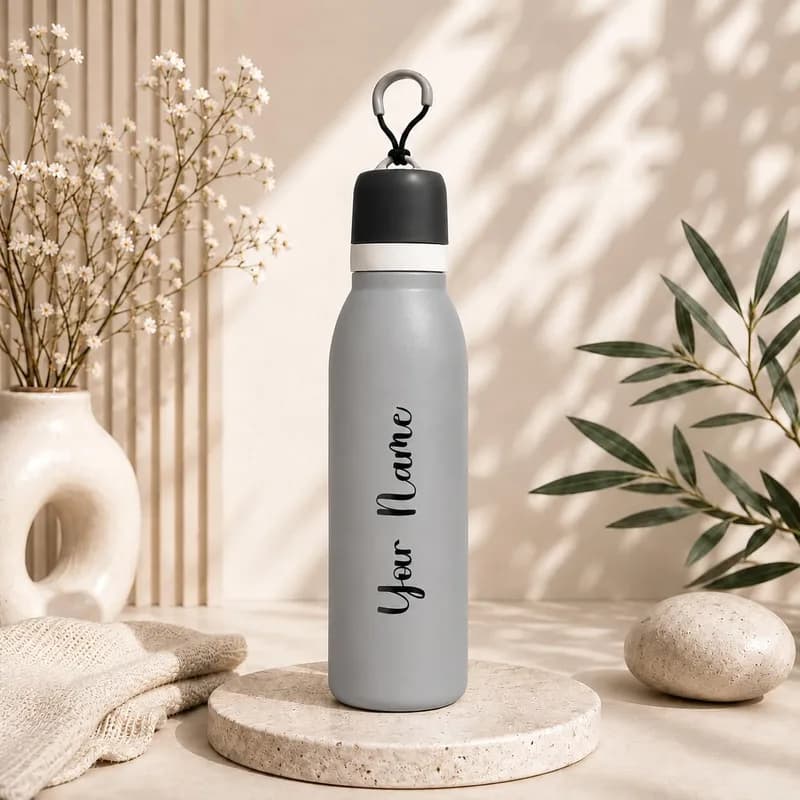 A matte gray water bottle with a black cap and carry loop, with “Your Name” printed along its side