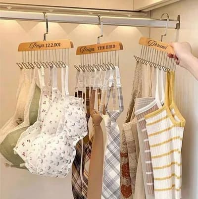 Hangers on a closet rail, their hooks holding bras and camisoles