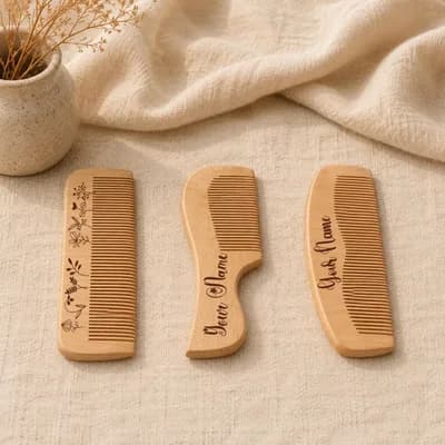 The three combs side by side on a cloth, each engraved in script